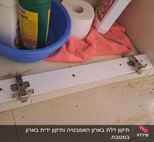 ארון פתוח עם חומרי ניקוי ומגבת